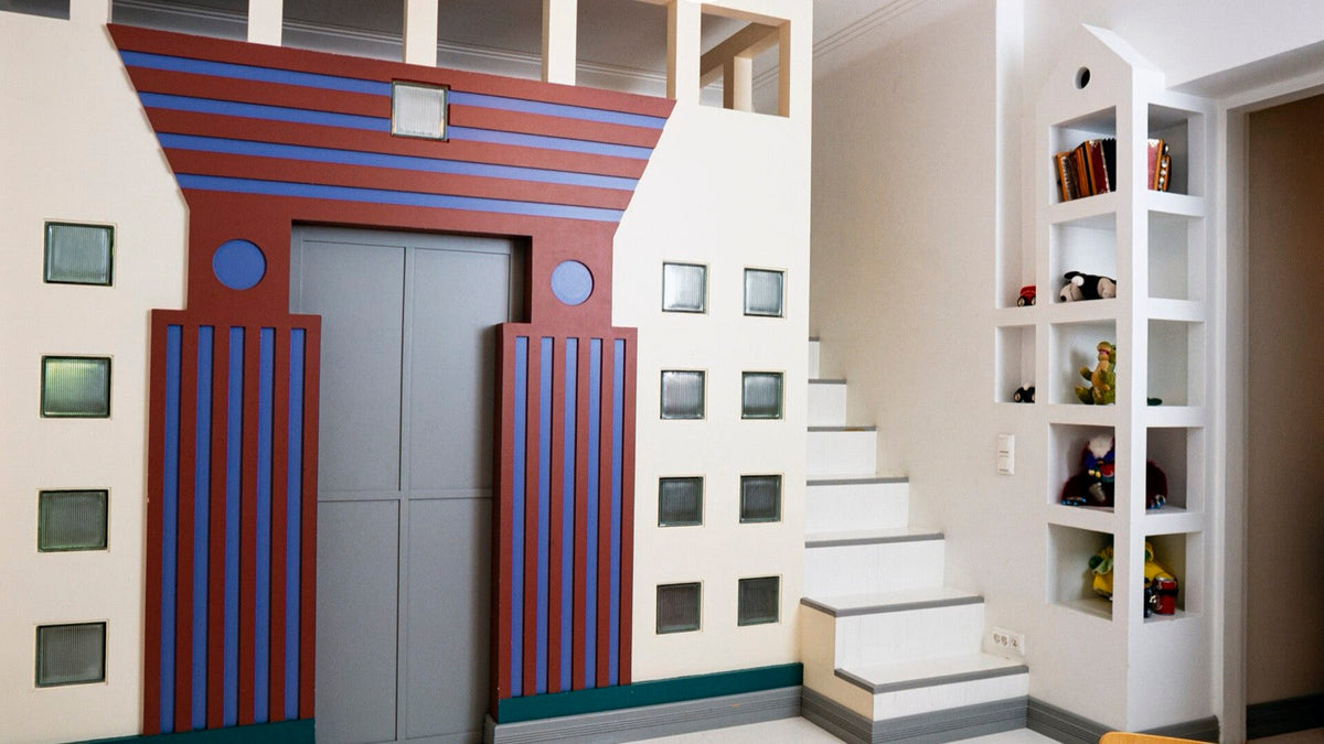 A 1993 children's room with a Michael Graves inspired doorway in red, blue, green, and gray geometric forms.