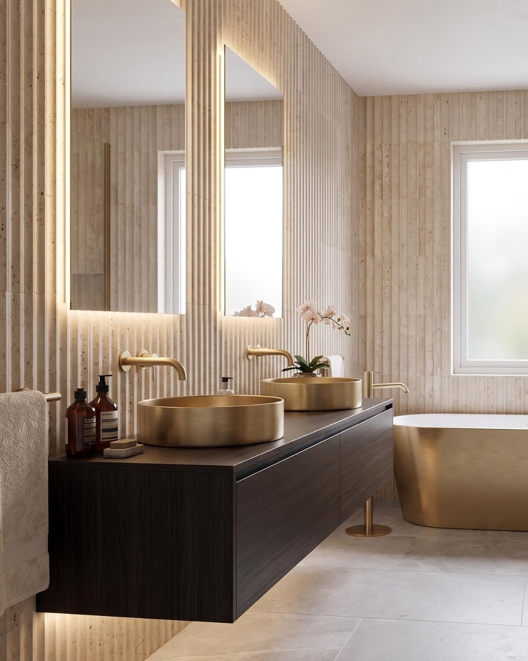 Ceres fluted travertine tile installed in a bathroom with brass fixtures