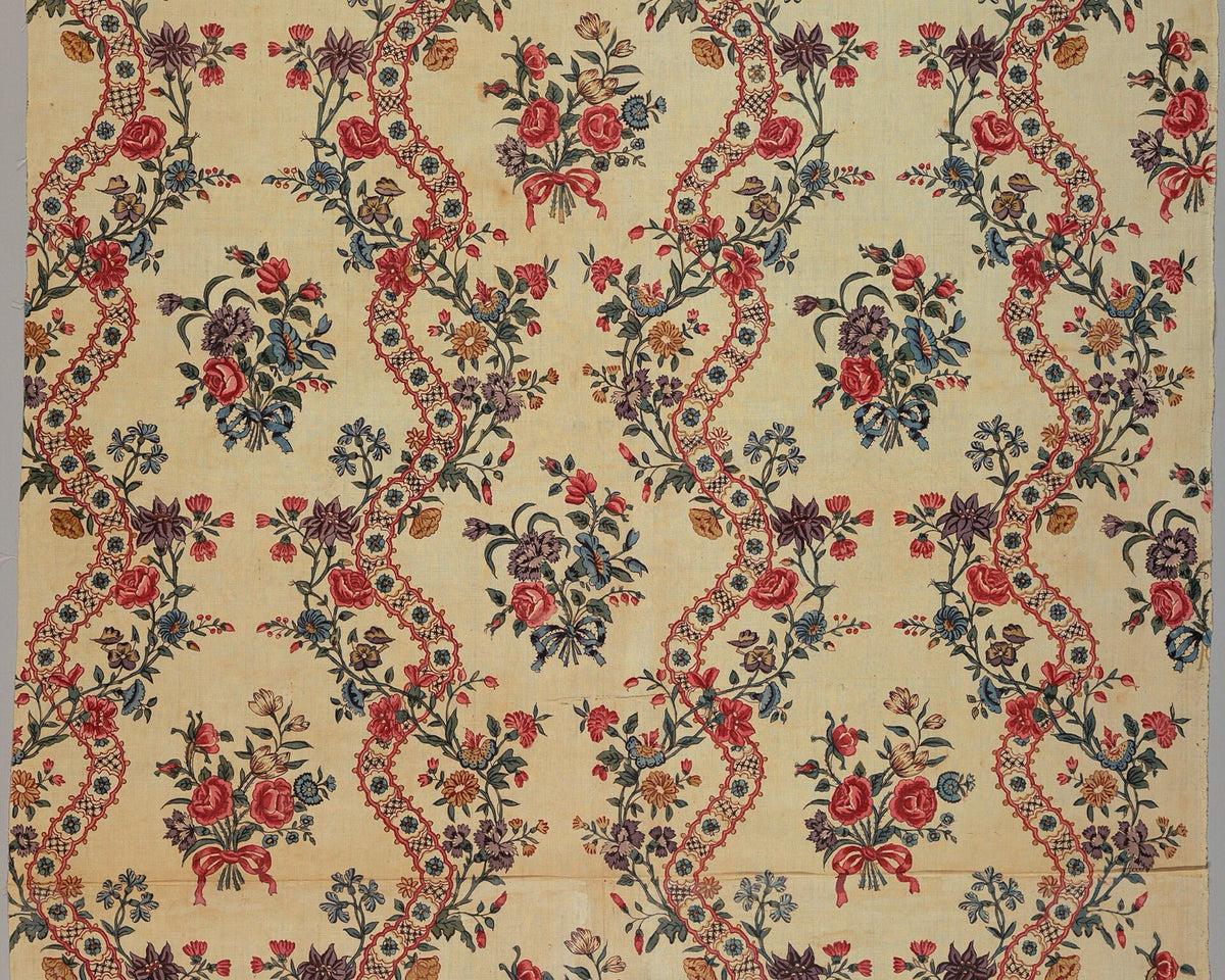An eighteenth-century Indian chintz with red, blue, purple, and green flowers arranged along a repeating serpentine lattice.