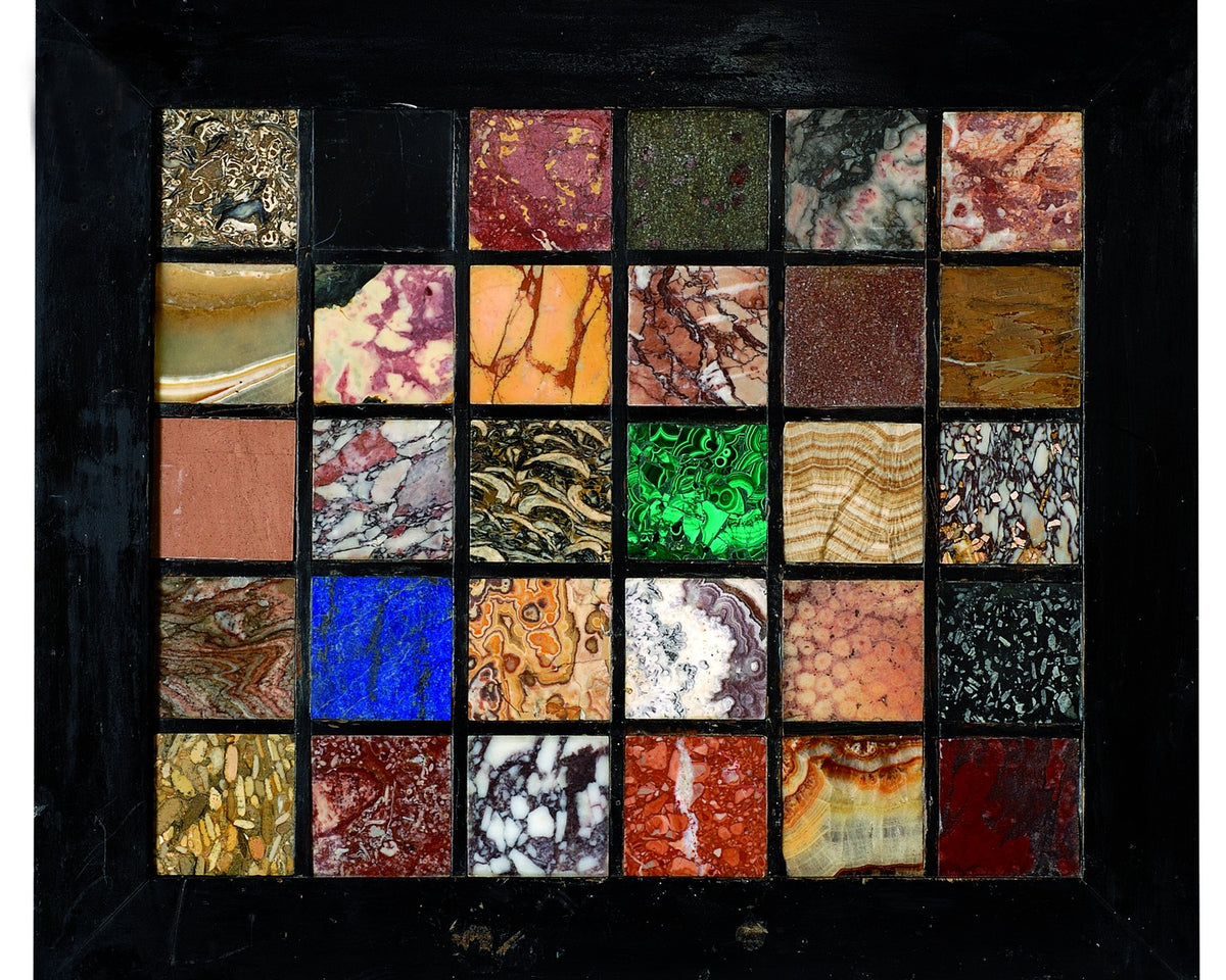 Framed grid of thirty marble specimens showing different colors, veining, and mineral structures.