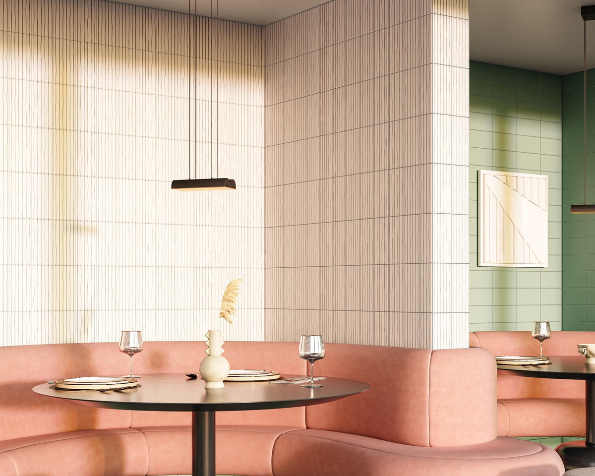 Pink restaurant banquette beside vertically patterned white tile and a saturated green wall.