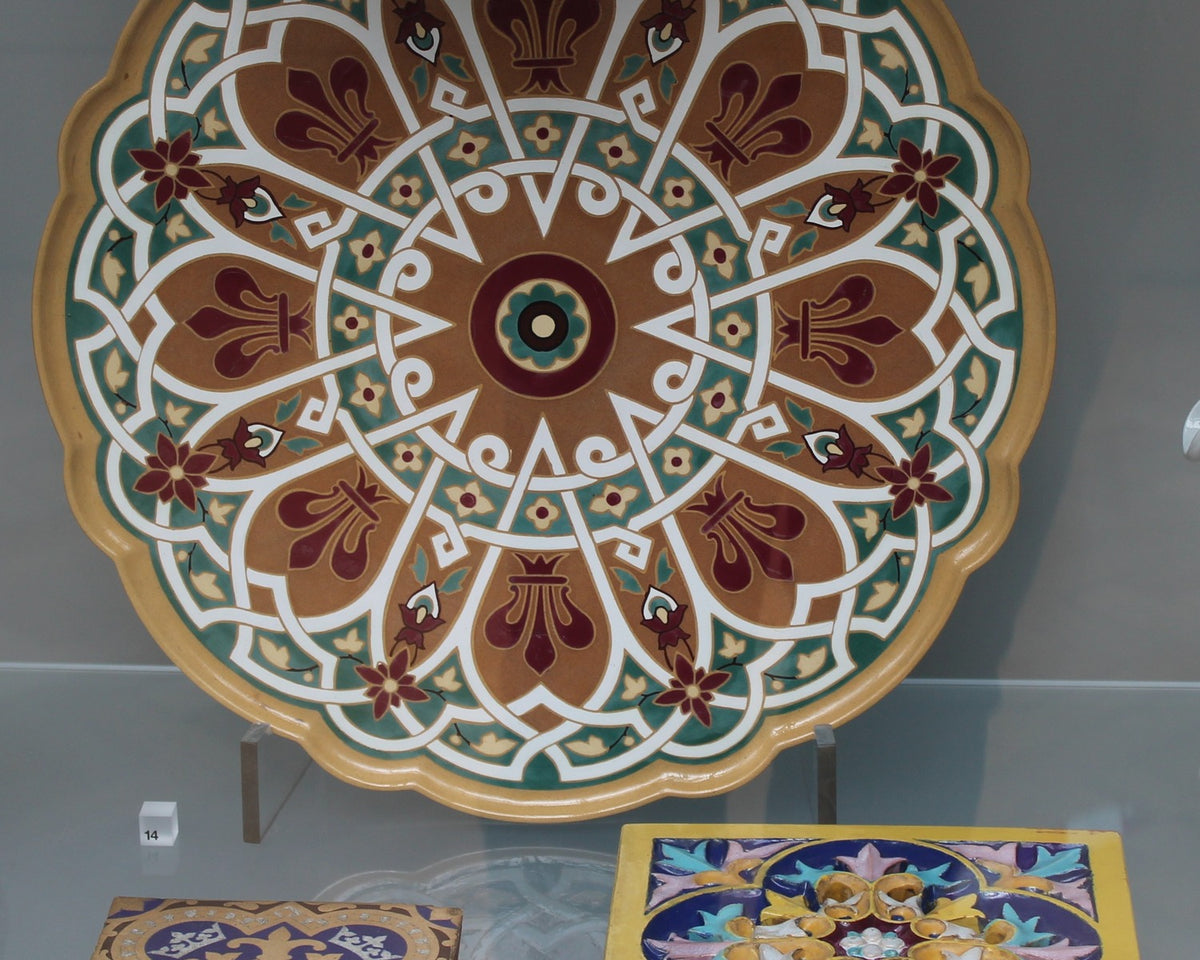 Round patterned Minton tray above square floor and stove tiles designed by A.W.N. Pugin.