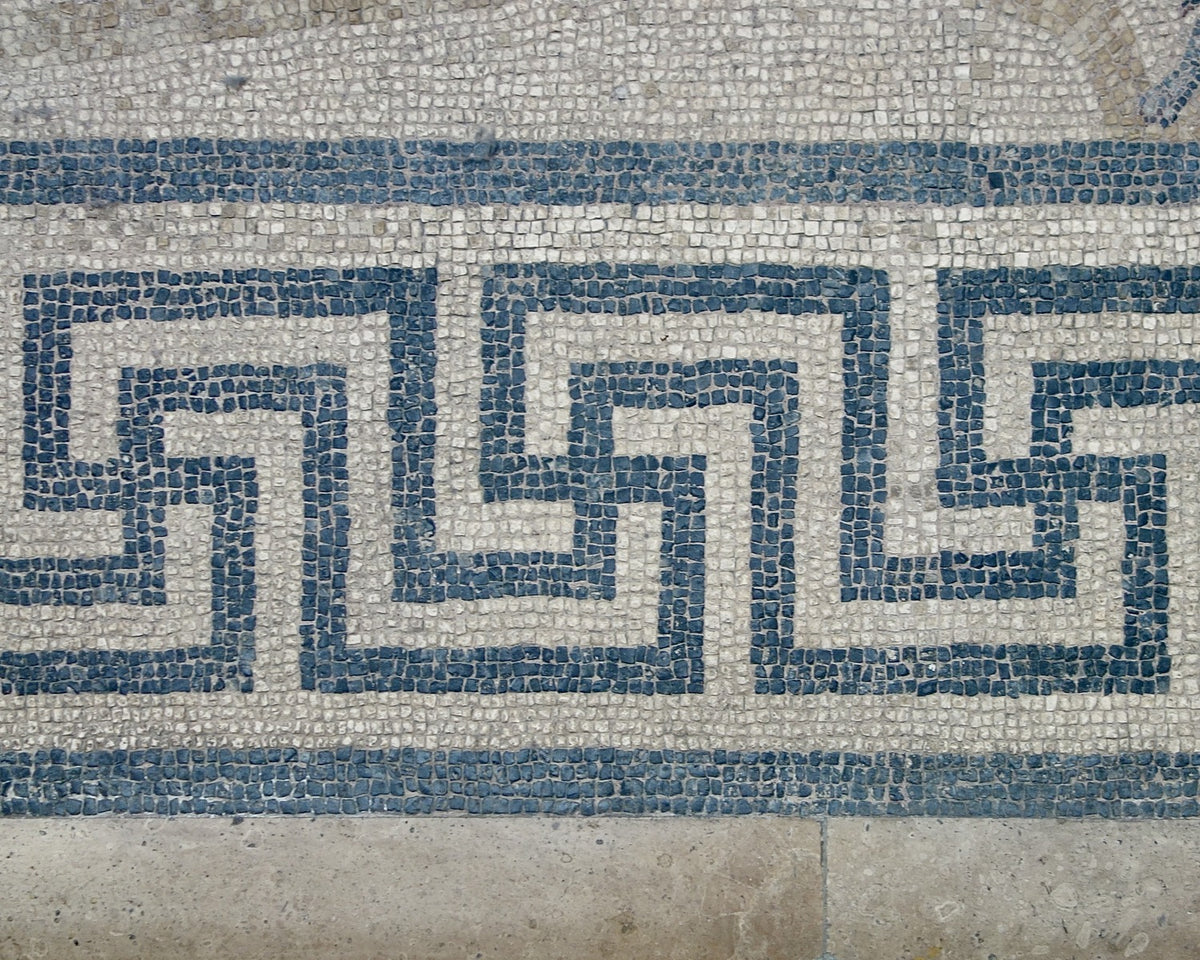 Blue-grey Greek-key border built from small tesserae in the Orpheus mosaic.