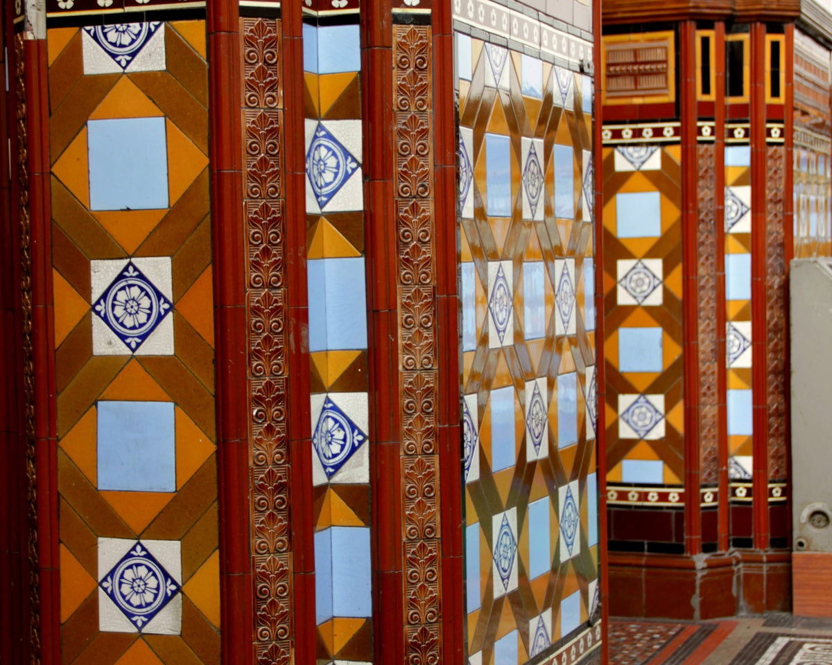 Historic glazed wall tile capped by a moulded dado in Leeds Central Library.