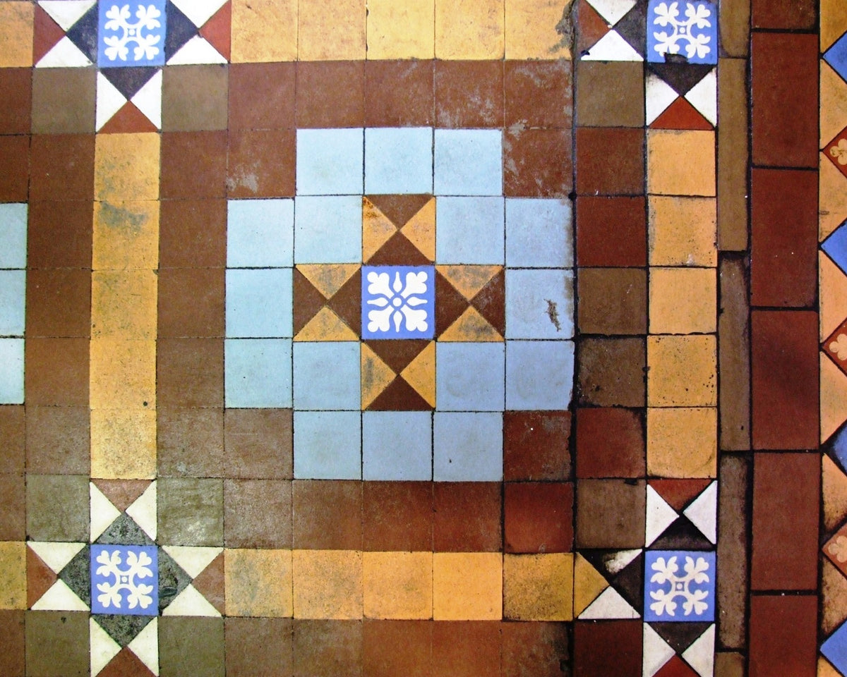 Victorian patterned floor tiles enclosed by a contrasting geometric border at Weaver Hall.