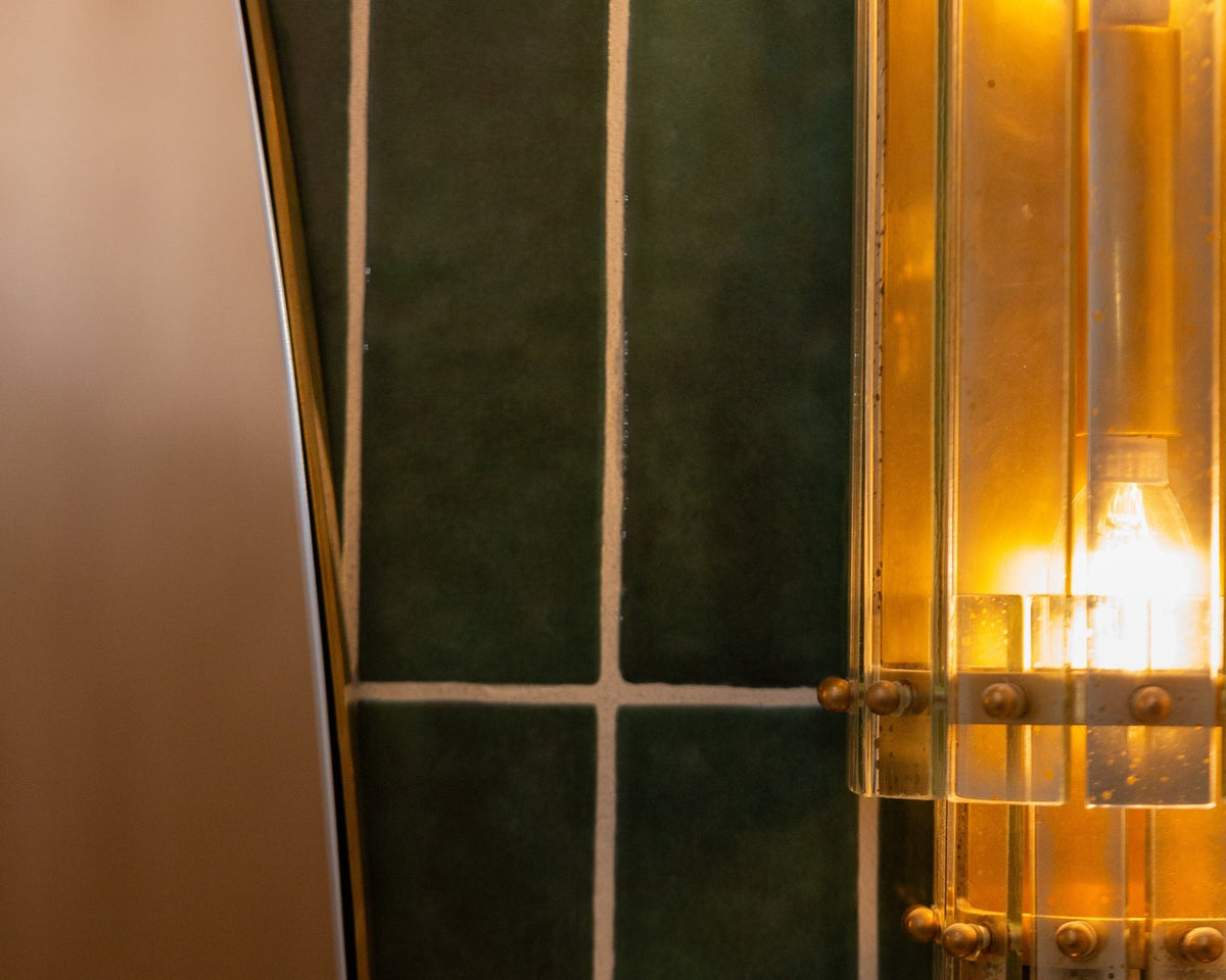 Grove green small-format tile with pale grout beside a warm reflected light.