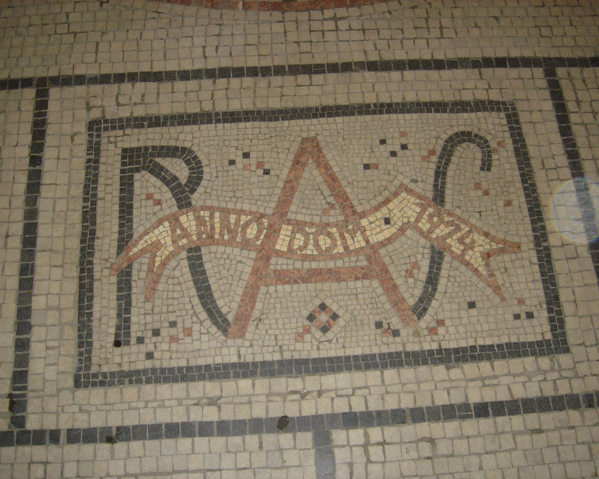 Geometric 1924 Art Deco floor mosaic with interlocking bands in Prague's Adria Palace.