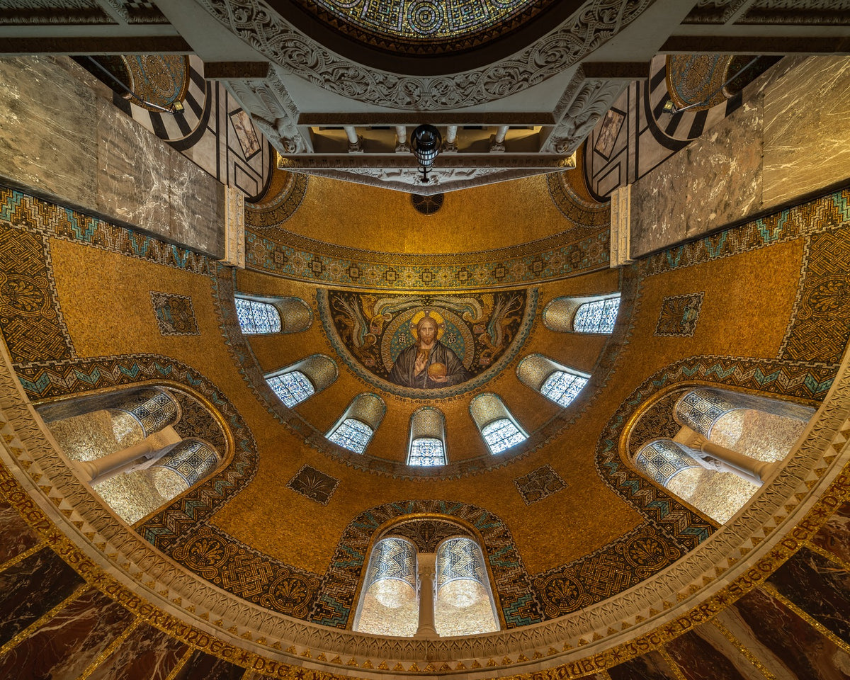 Gold mosaic covering a curved church apse and changing in brightness across the vaulted surface.