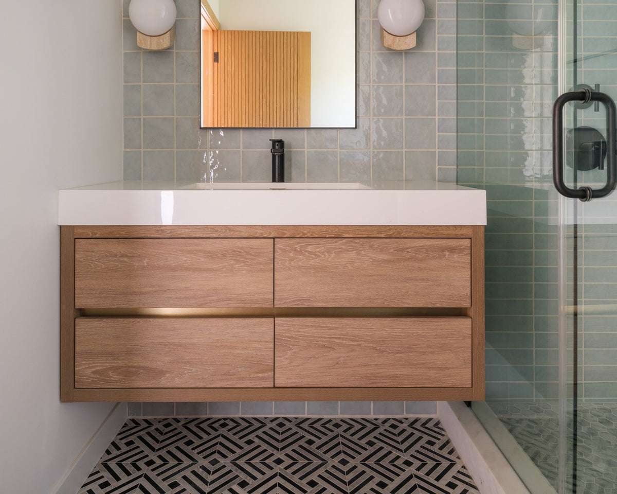 Parallax Noir black-and-white geometric mosaic floor in a pale contemporary bathroom.