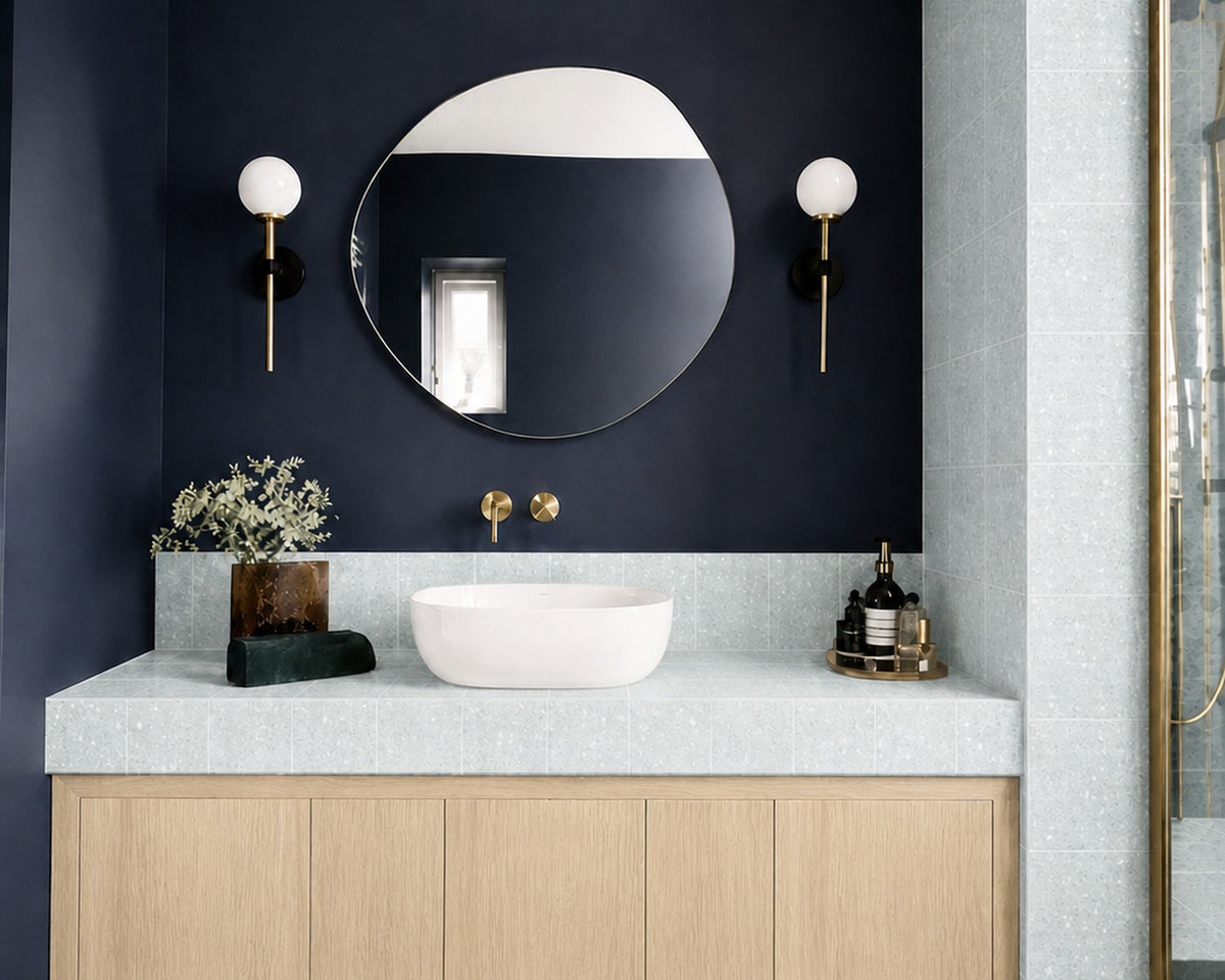 Dorothy blue terrazzo tile installed in a navy bathroom with a white oak vanity
