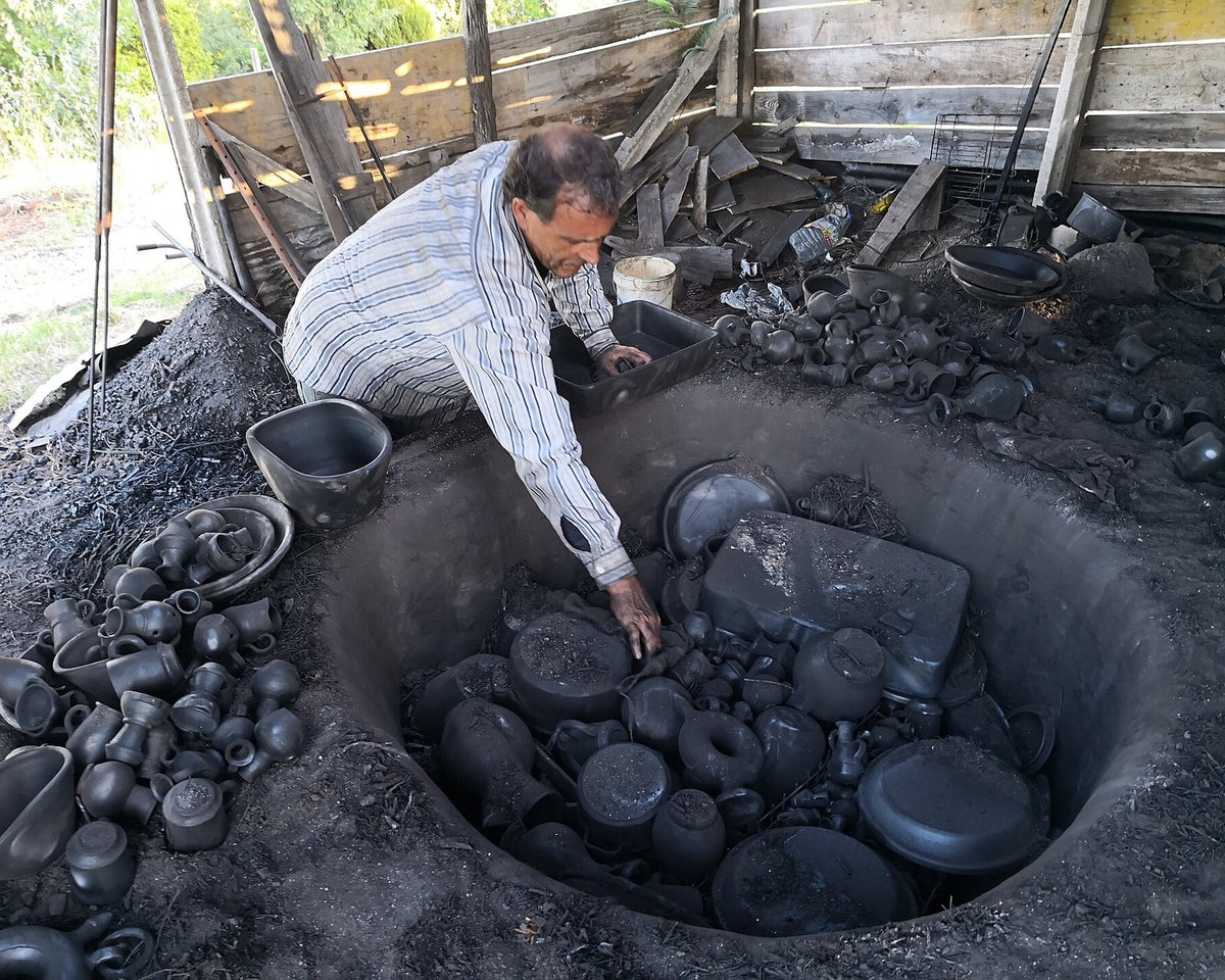 Potter Jorge Ramalho removing Bisalhães black pottery from a kiln