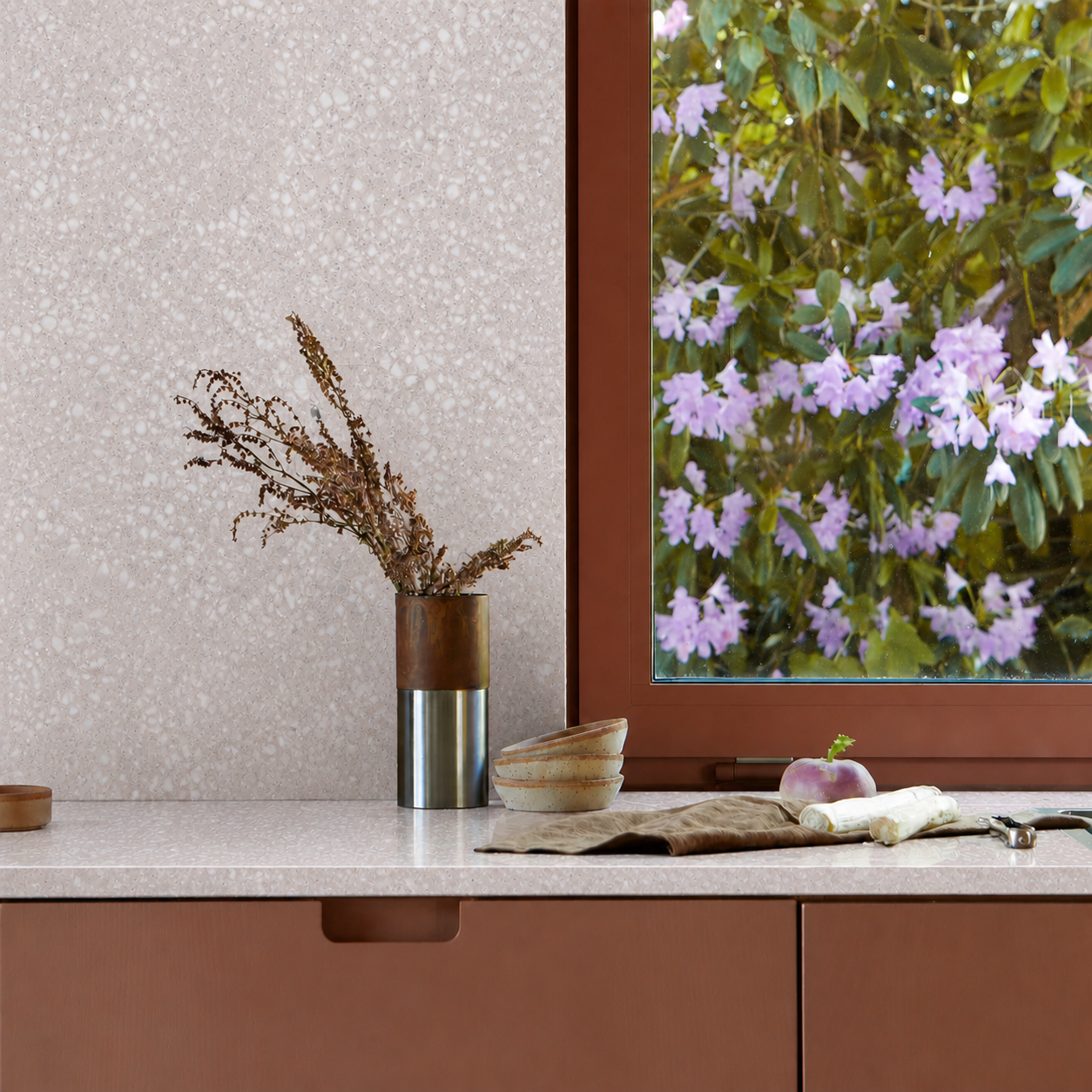 Toto Intuitive pink terrazzo kitchen installation with rust cabinetry and a garden window