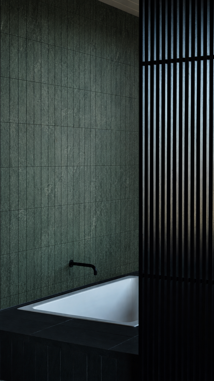 Ollivera green marble mosaic tile in a dark bathroom with soaking tub and black slatted shower divider