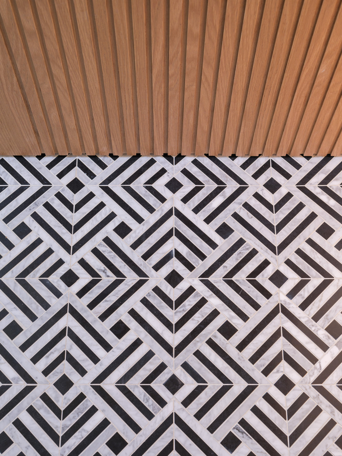 Parallax Noir marble mosaic floor and wood detail installation